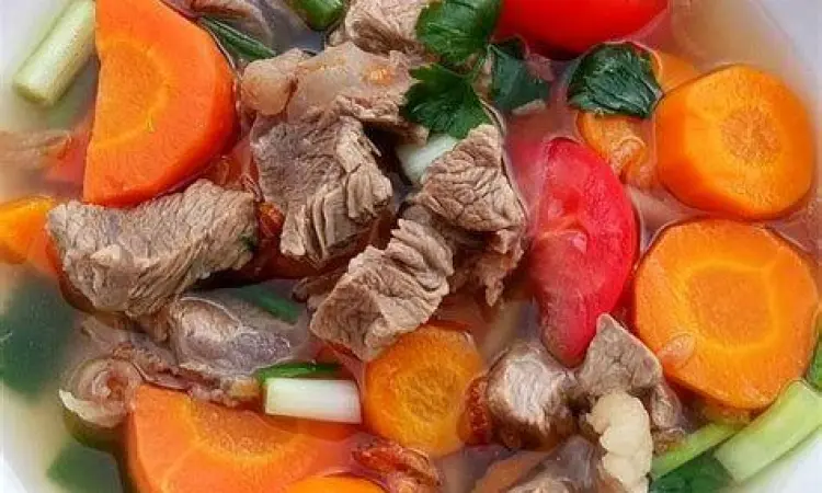 Sajian sop daging sapi bening dengan sayuran wortel dan kentang