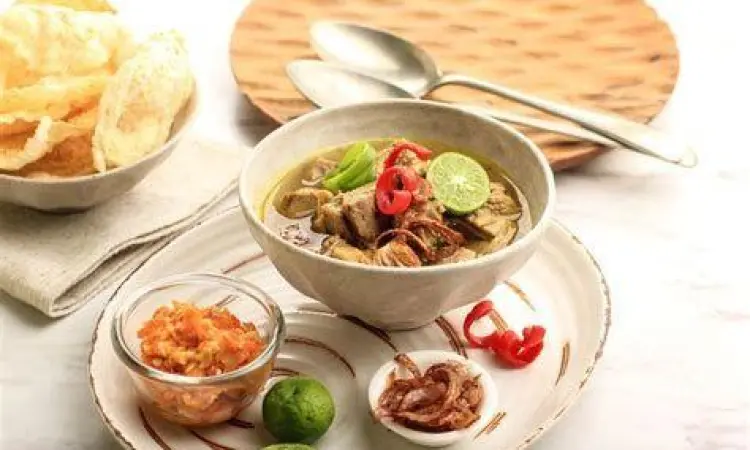 Sajian soto daging lengkap dengan telur rebus dan emping
