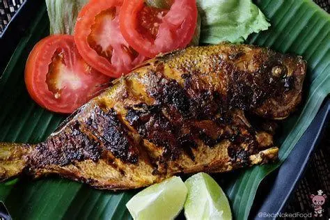 Proses Membakar Ikan Proses pengolesan bumbu pada ikan yang sedang dibakar