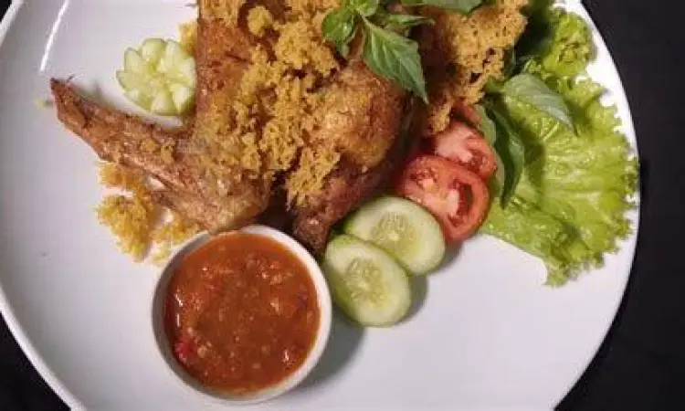 Penyajian ayam kremes dengan sambal terasi dan lalapan segar