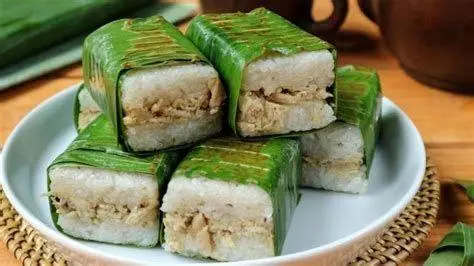 Lemper Ayam Tradisional Tumpukan lemper ayam yang dibungkus daun pisang hijau segar
