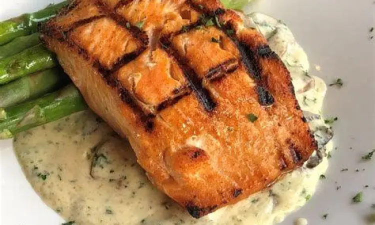 Ikan salmon panggang dengan asparagus sebagai menu makan malam mewah