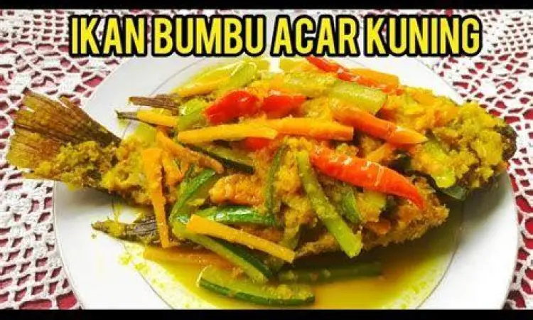 Ikan Bumbu Acar Kuning Sajian ikan goreng yang disiram dengan bumbu acar kuning kental