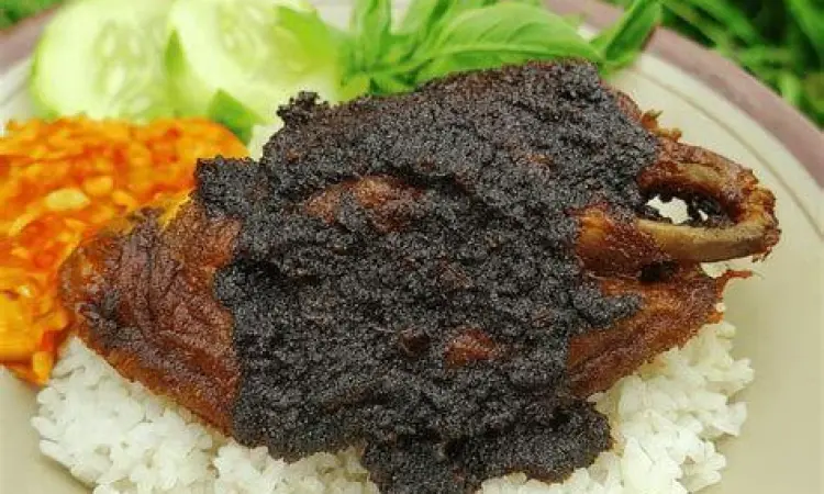 Proses Karamelisasi Bumbu Hitam Proses memasak bumbu hitam bebek Madura di atas wajan