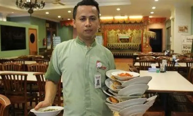 Teknik Manatiang Piriang Pelayan membawa banyak piring nasi padang