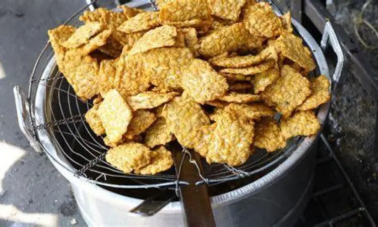 Proses menggoreng tempe hingga kuning keemasan