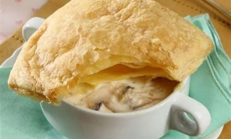 Zuppa soup dalam mangkuk keramik dengan pastry cokelat keemasan