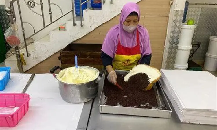 Proses pengolesan selai srikaya tebal pada roti ganda