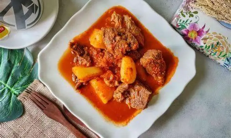 Memasak Asam Padeh Proses memasak asam padeh daging di kuali tradisional