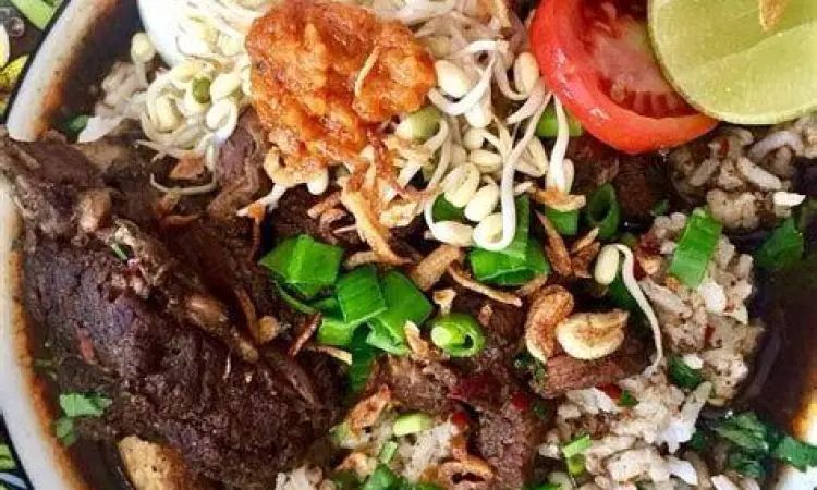 Semangkuk nasi rawon dengan potongan daging sapi empuk