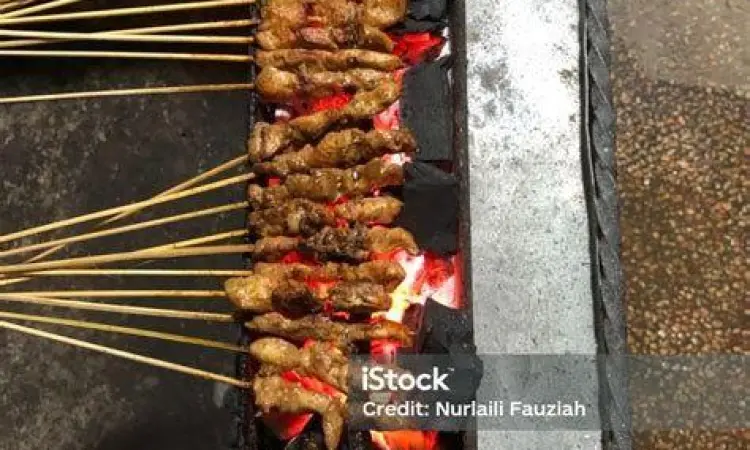 Proses pembakaran sate sapi di atas arang batok kelapa