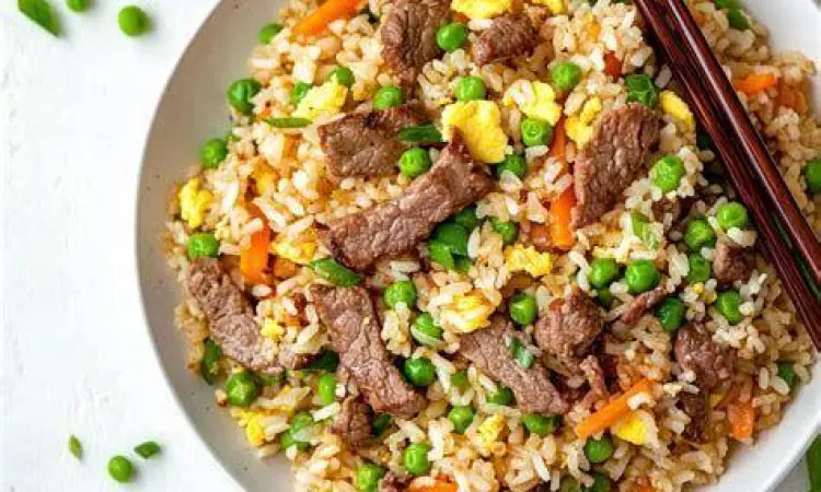 Proses memasak nasi goreng sapi di wajan panas dengan api besar