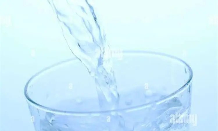 Kualitas Air Minum Menuangkan air mineral ke dalam gelas kristal