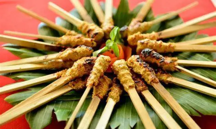 Sate lilit ayam dengan bumbu kuning di atas piring saji