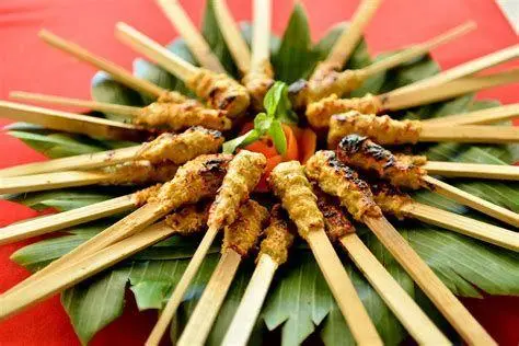 Penyajian Sate Lilit Bali Sate lilit ayam dengan bumbu kuning di atas piring saji