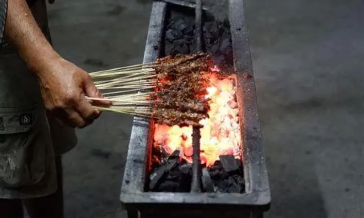 Sate lilit yang sedang dibakar di atas panggangan arang