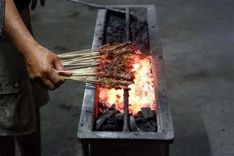 Proses Pembakaran Sate Lilit Sate lilit yang sedang dibakar di atas panggangan arang