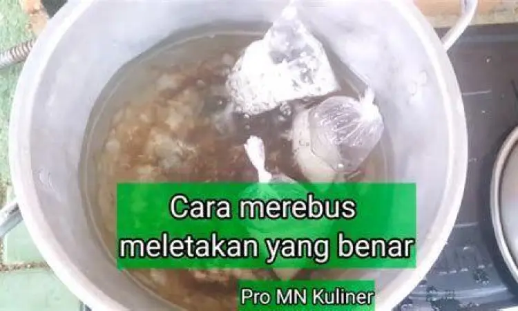 Perebusan Lontong Tradisional Proses merebus lontong dalam panci besar dengan posisi berdiri