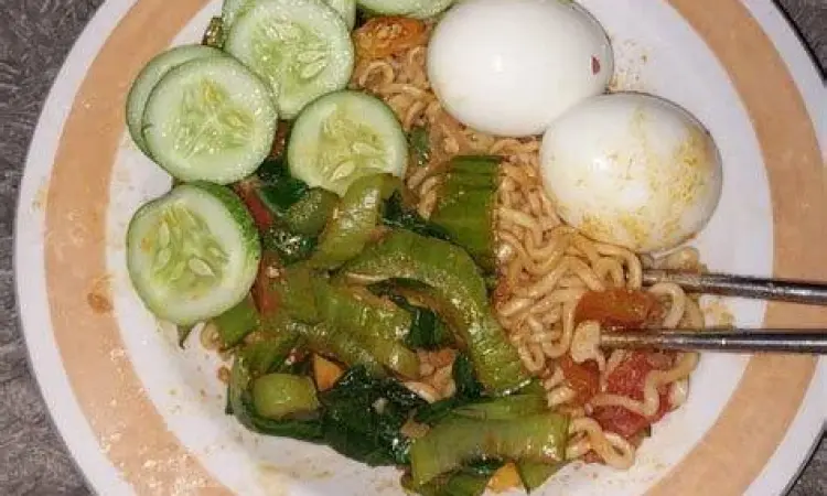 Kuning telur meleleh di atas mie rebus