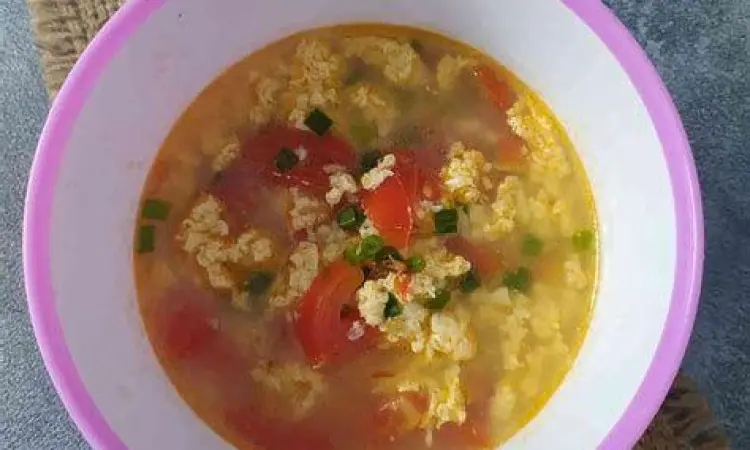 Tomat merah segar dan telur ayam di atas meja dapur