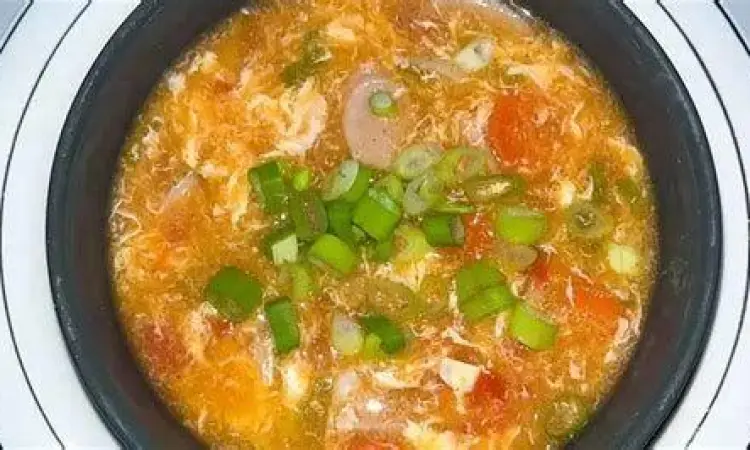 Proses menuangkan telur kocok ke dalam kuah tomat mendidih