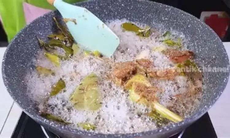 Proses menumis bumbu halus opor di wajan hingga tanak
