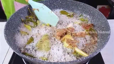 Teknik Menumis Bumbu Proses menumis bumbu halus opor di wajan hingga tanak