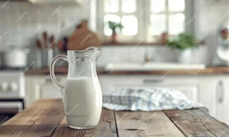 teko susu segar di meja kayu