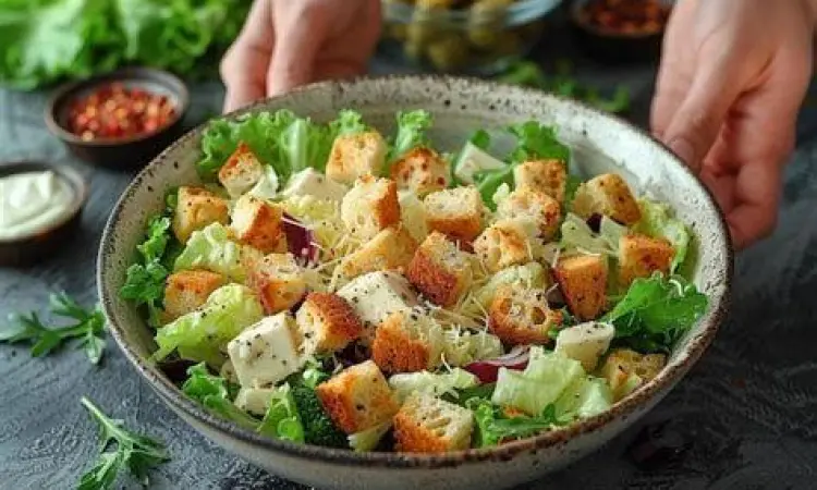 Proses Tossing Salad Selada romaine yang sedang dicampur dengan dressing di mangkuk kayu besar