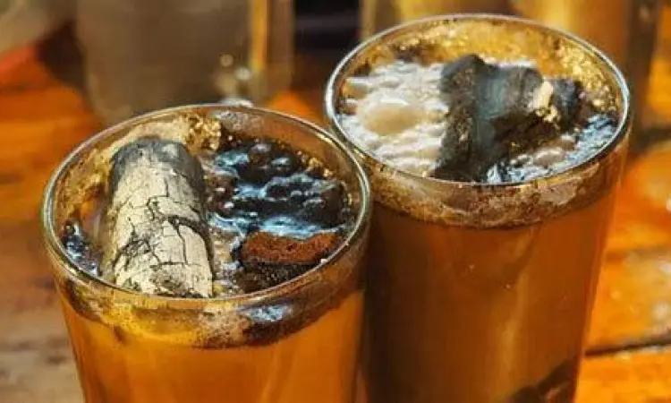 Detail arang membara dalam segelas kopi joss