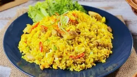 Penyajian Nasi Goreng Kunyit Plating mewah nasi goreng kunyit di restoran