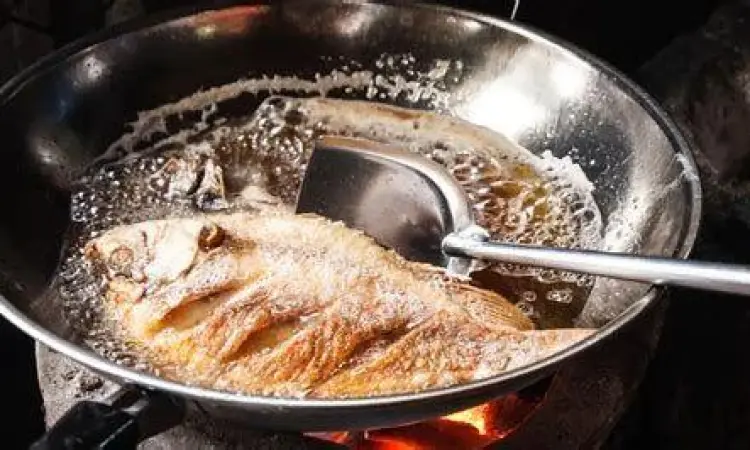 Proses menggoreng ikan kecil dalam minyak panas